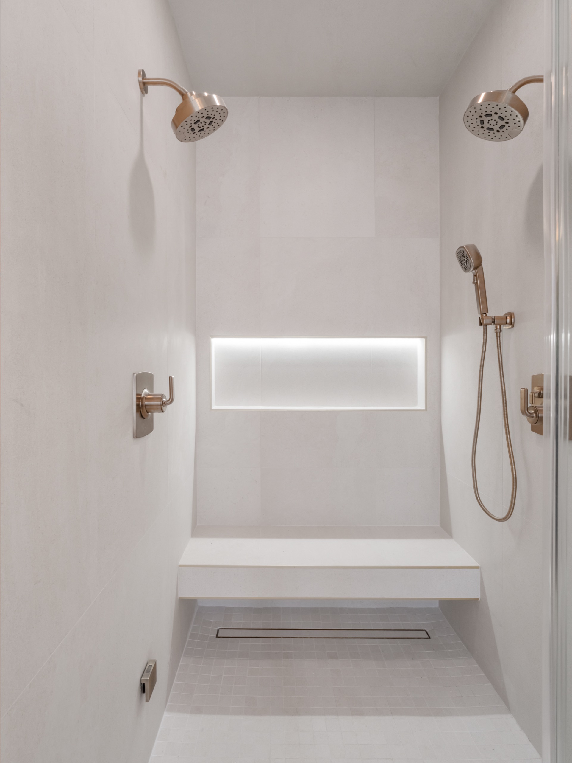 Spa shower with floating bench, lit niche and champagne fixtures