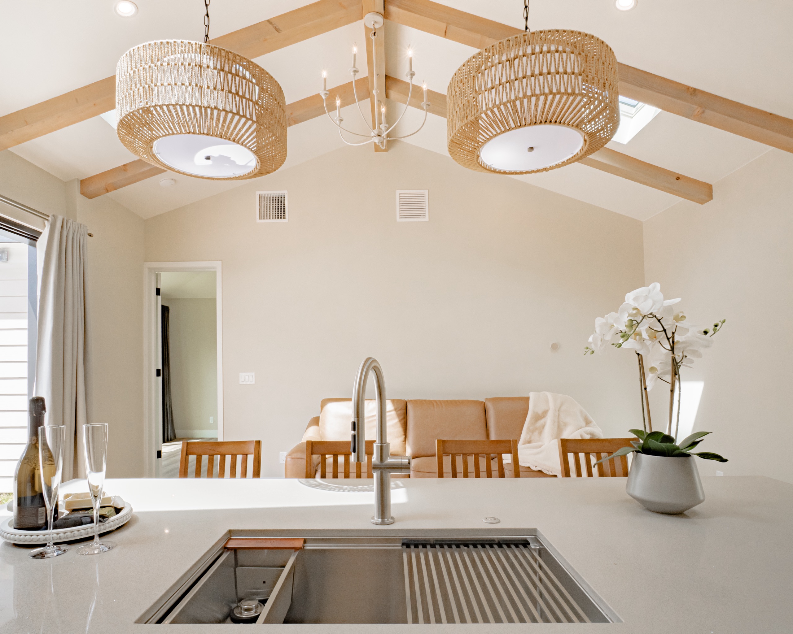 Kitchen sink beneath a gabled window with white-oak open shelving