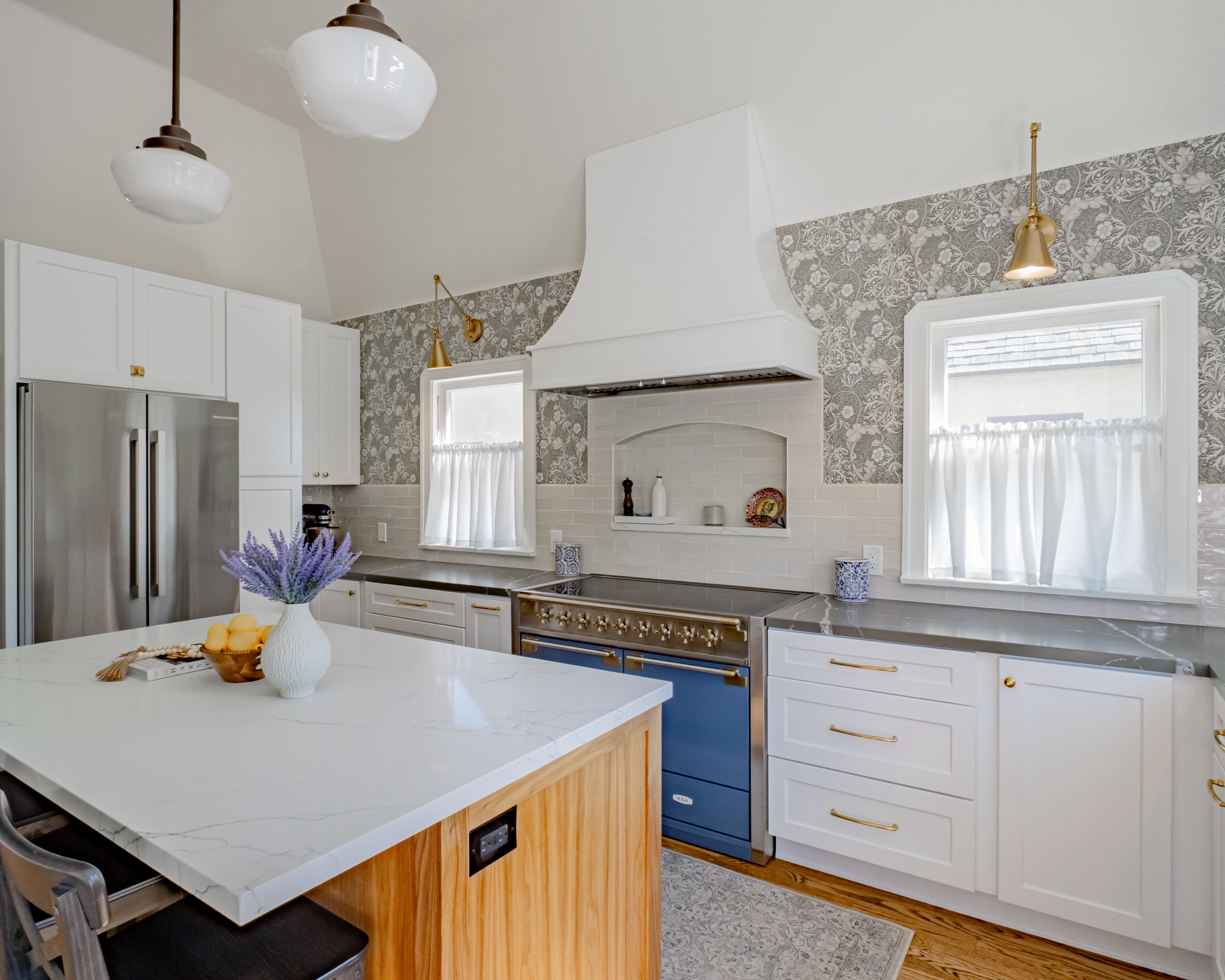 A finished kitchen with a marble waterfall island